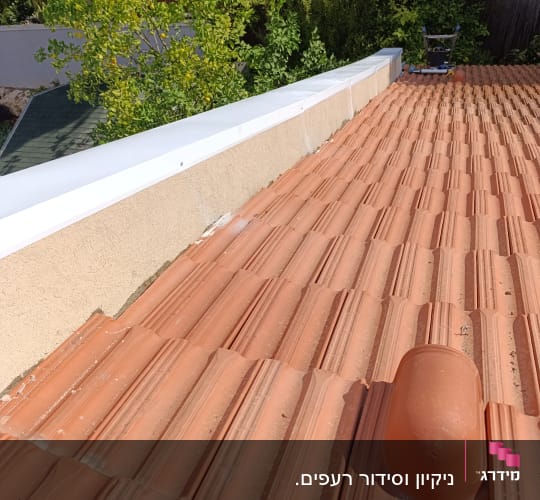 רעפים כתומים על גג עם צינור אוורור